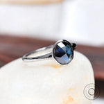 Angled view of oval blue moissanite solitaire engagement ring
