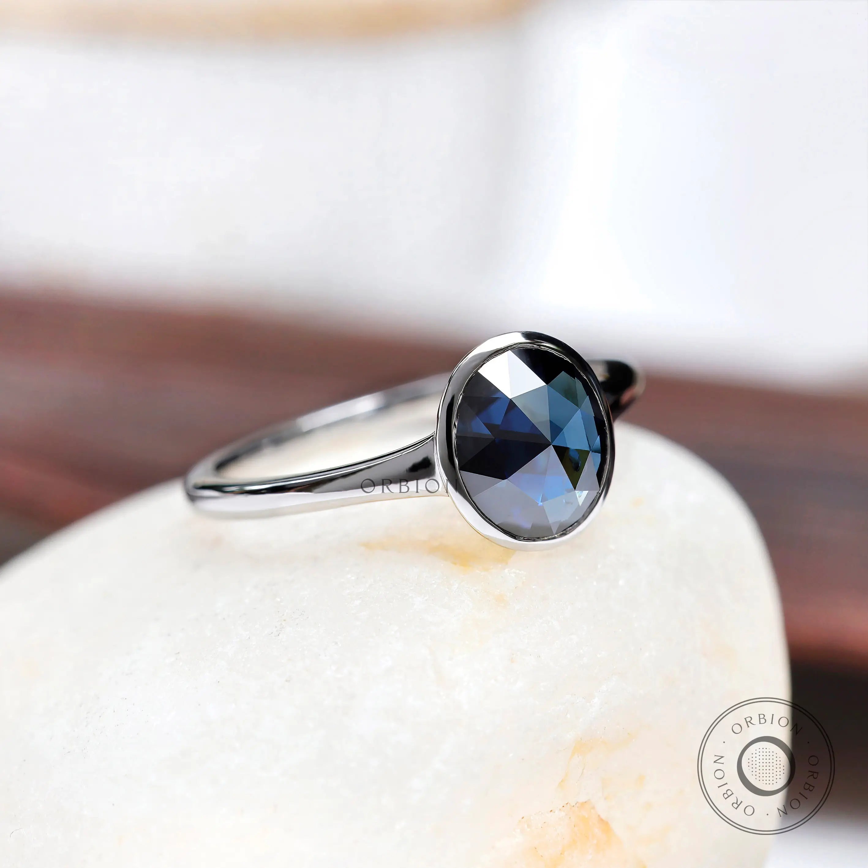 Angled view of oval blue moissanite solitaire engagement ring