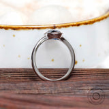 Underside view of oval blue moissanite bezel ring in white gold