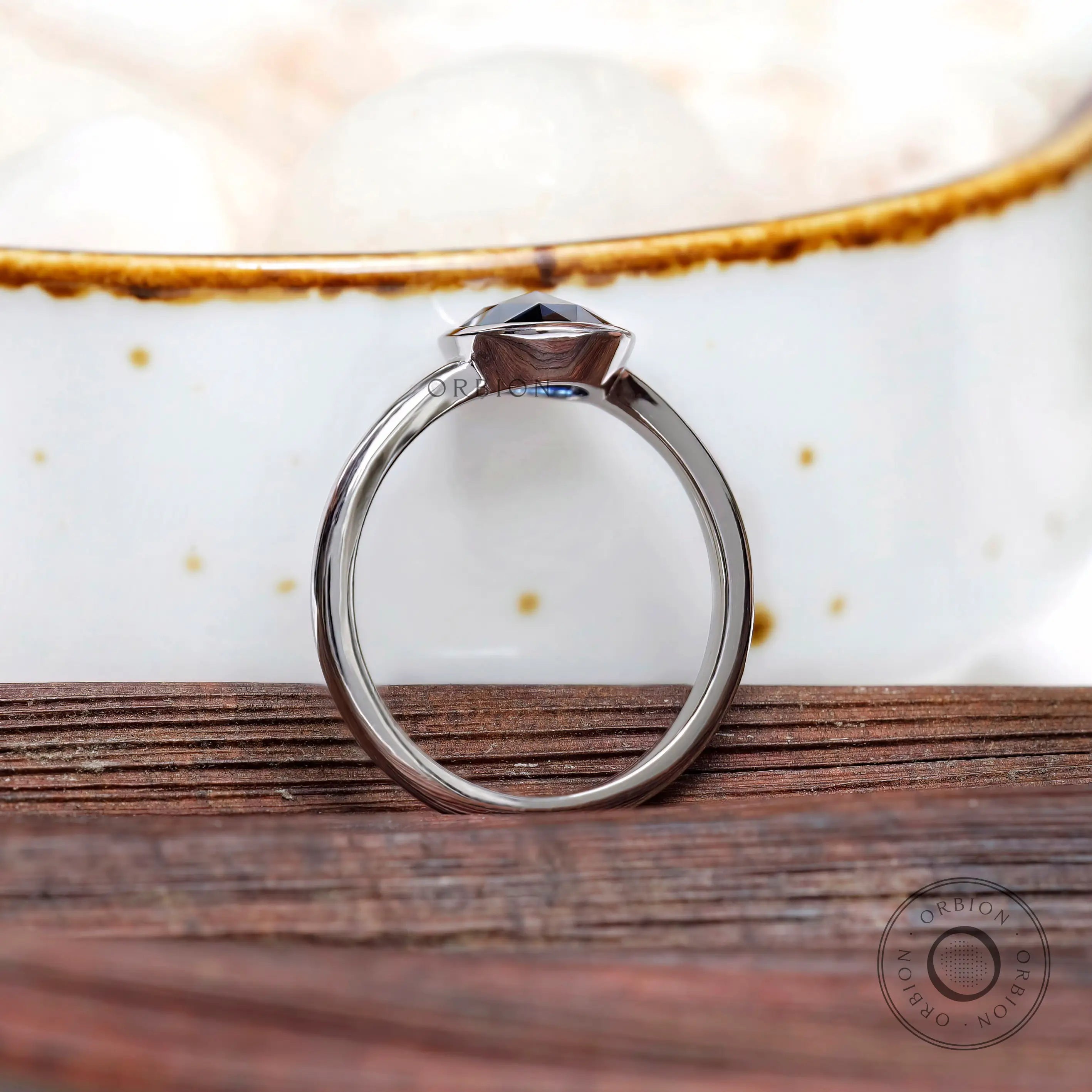 Underside view of oval blue moissanite bezel ring in white gold