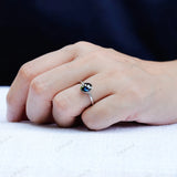 Hand shot of minimalist blue moissanite solitaire engagement ring