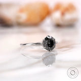 Angled view highlighting the round grey moissanite solitaire in a white gold