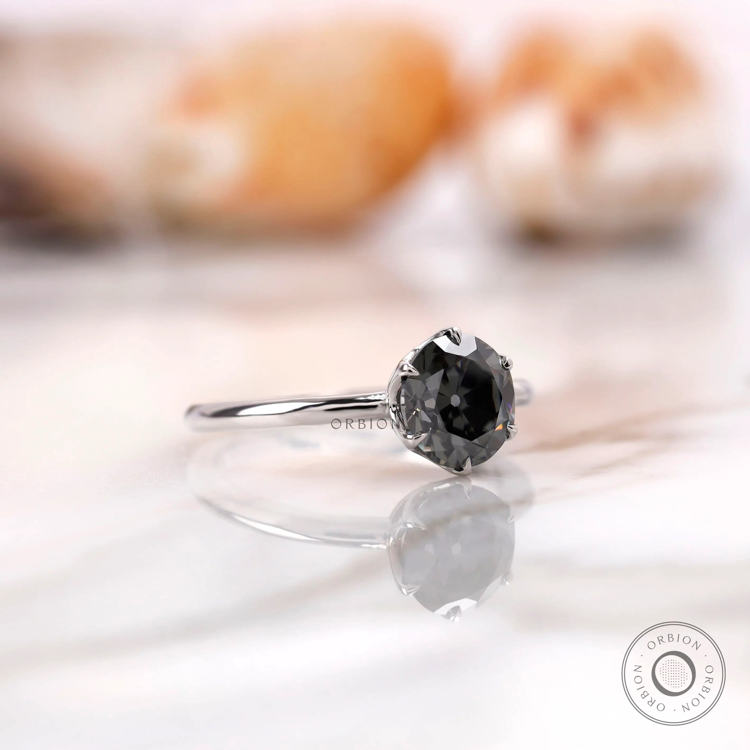 Angled view highlighting the round grey moissanite solitaire in a white gold