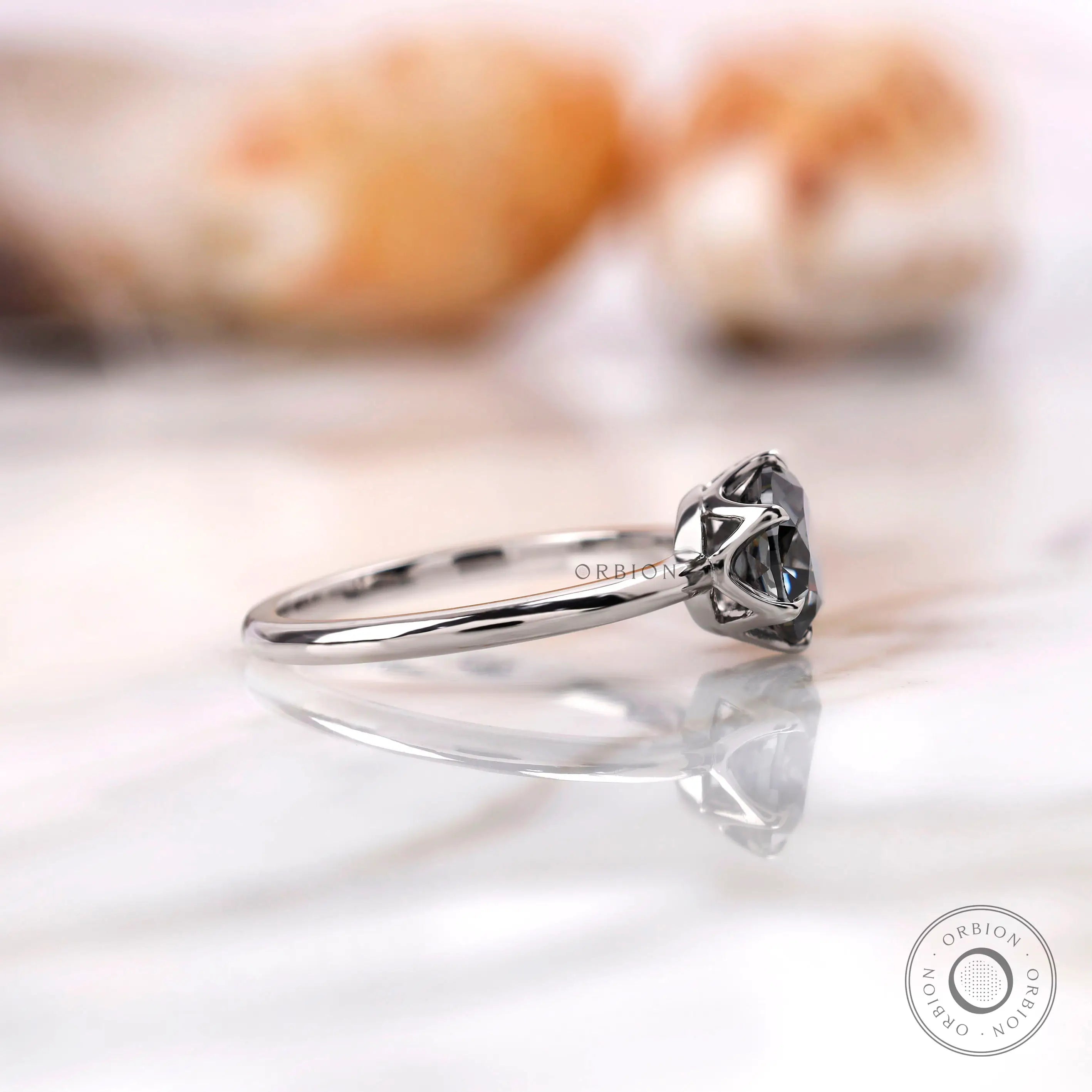 Side profile showcasing the slim band and elevated grey moissanite setting