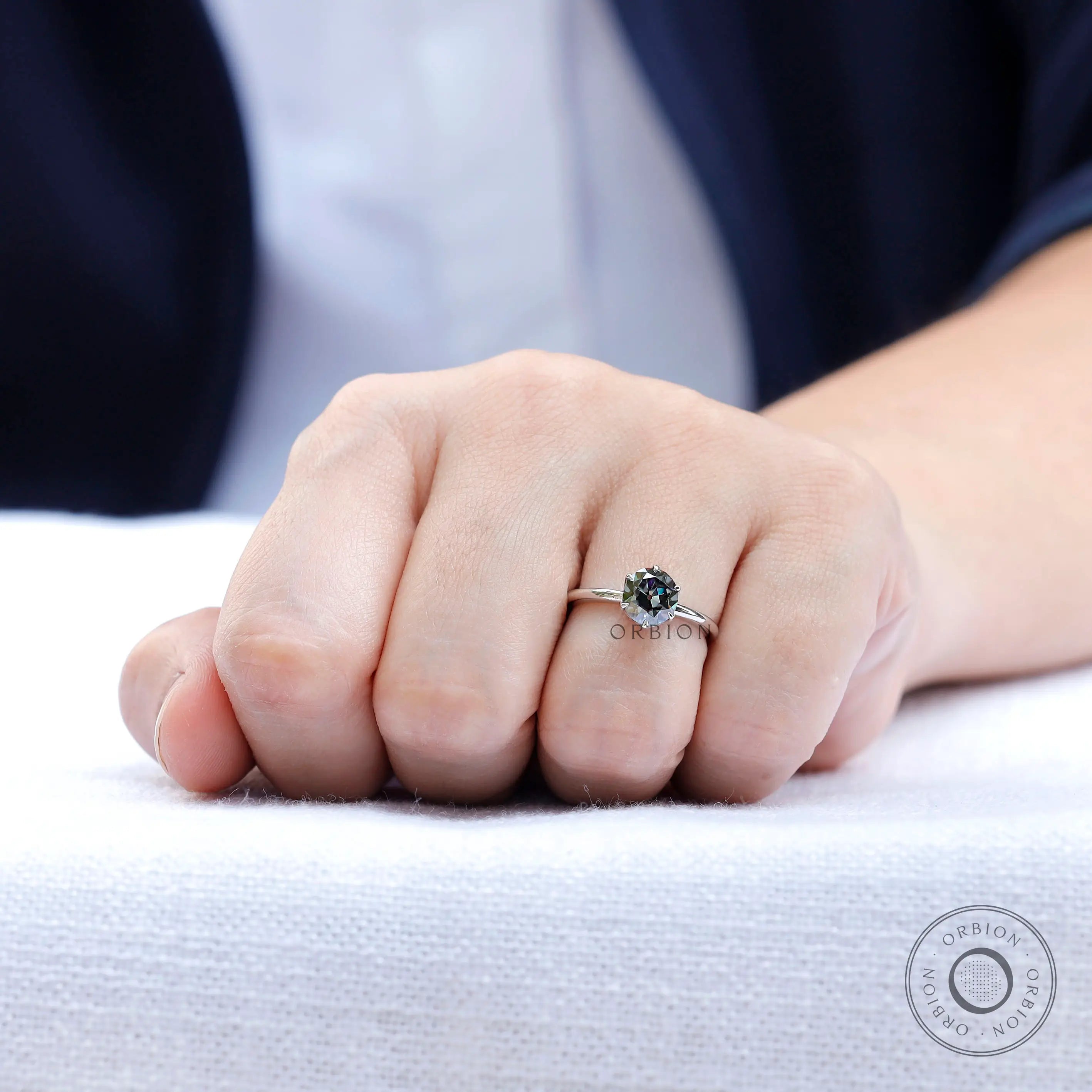 Close up on hand view highlighting the brilliance of the grey moissanite