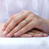 Elegant and sophisticated moissanite engagement ring in 10K yellow gold on a hand model's finger.