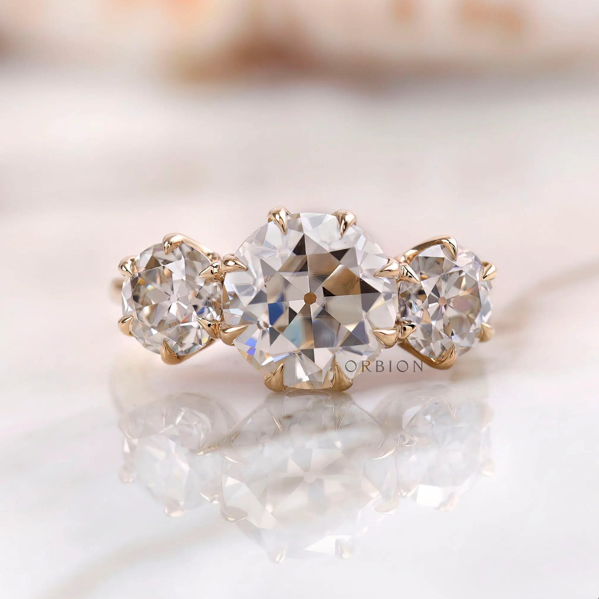 Round Old European cut three stone moissanite ring in 10K yellow gold front view