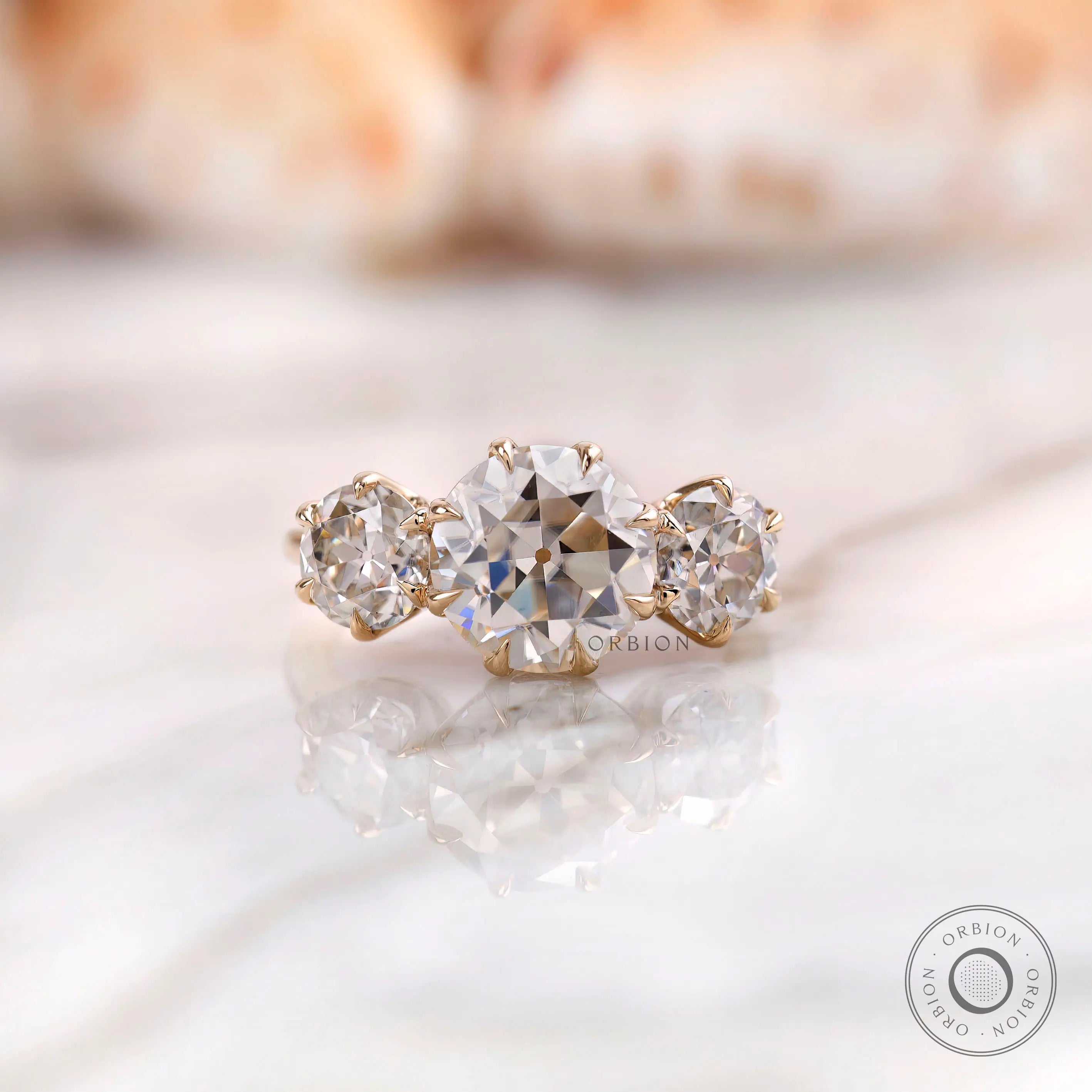 Round Old European cut three stone moissanite ring in 10K yellow gold front view