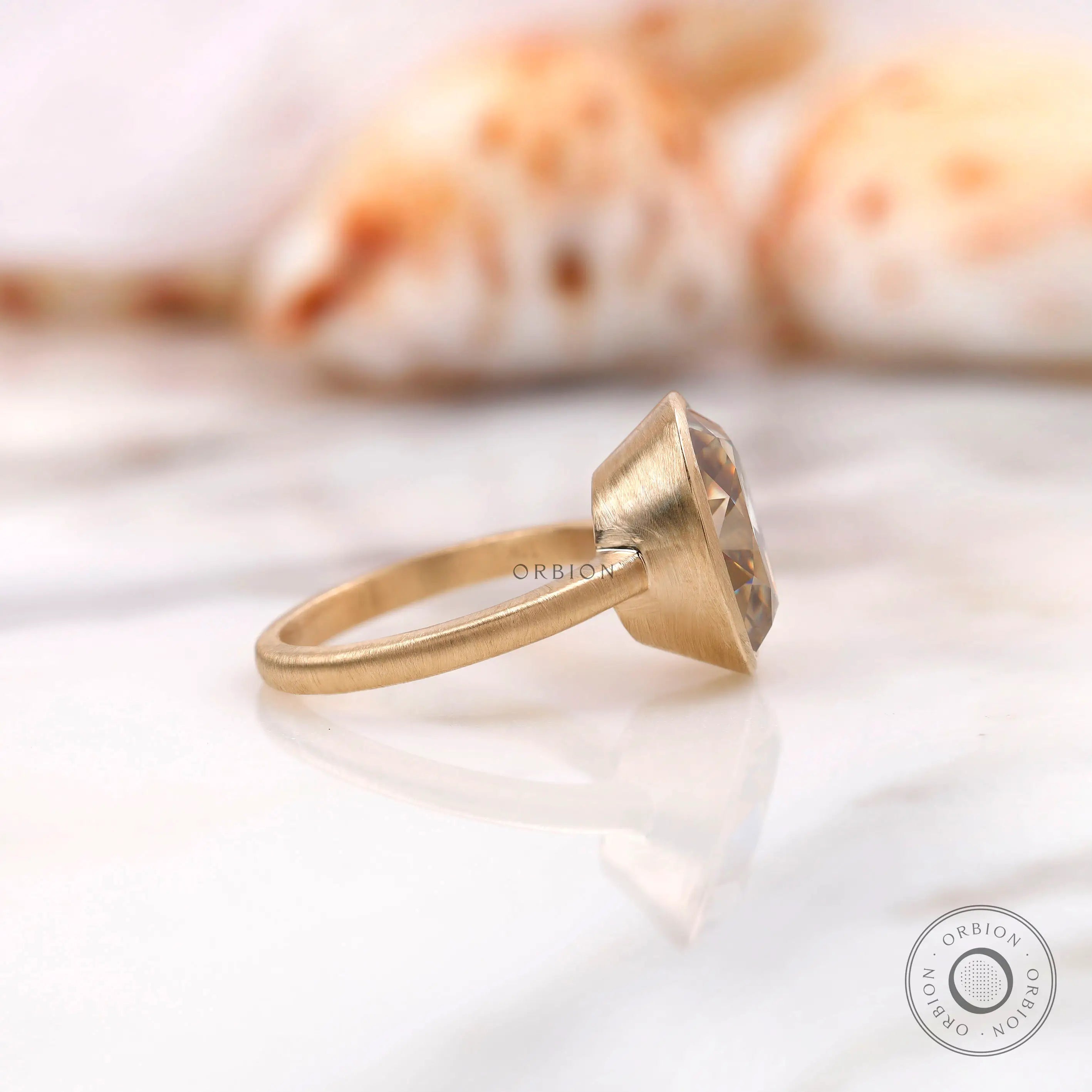 Side profile of bezel set oval champagne ring