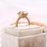 Bezel set oval ring shown side on box