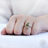 Bezel set oval champagne ring worn on hand