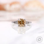 Front view of a champagne cushion moissanite ring with baguette side stones set