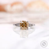 Front view of a champagne cushion moissanite ring with baguette side stones set