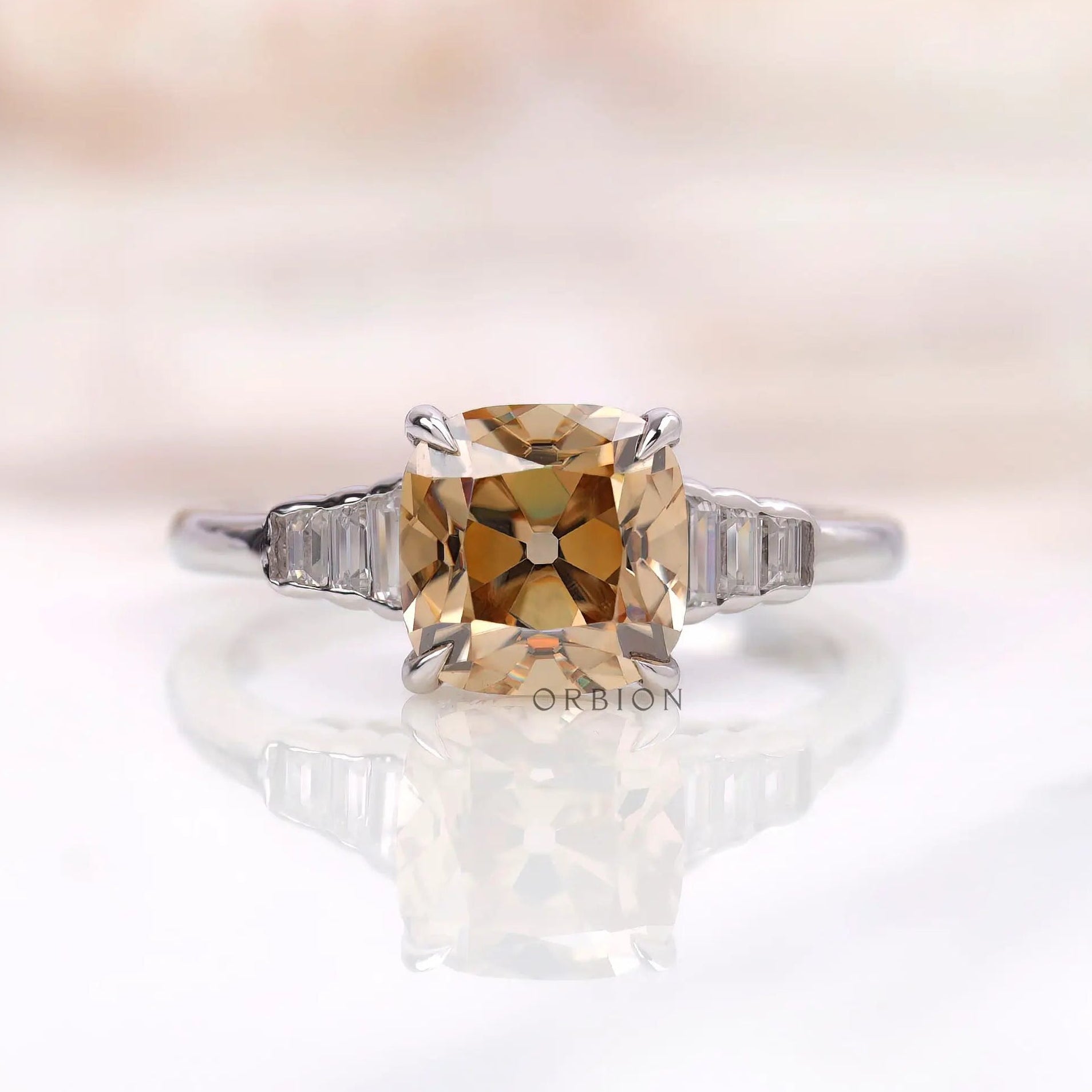 Front view of a champagne cushion moissanite ring with baguette side stones set