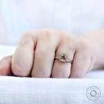 Champagne cushion moissanite ring with baguette side stones worn on hand