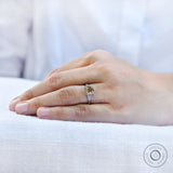 Hand wearing a champagne cushion moissanite engagement ring with baguette side stones