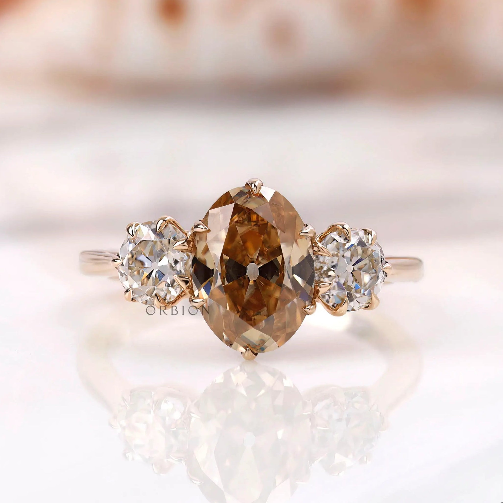 Three stone oval champagne moissanite ring shown from front