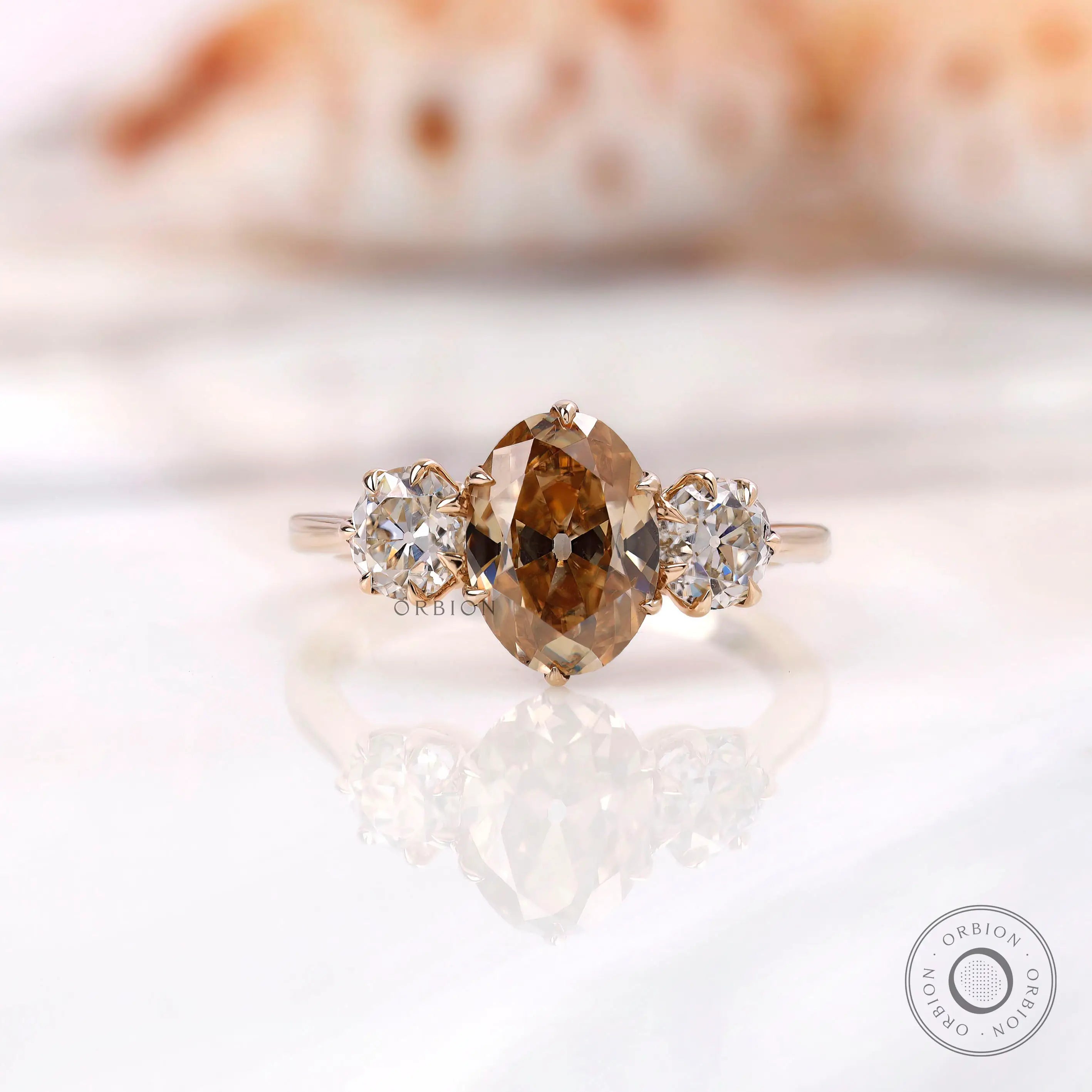 Three stone oval champagne moissanite ring shown from front