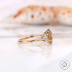 Prong-set oval center stone with gold band side view