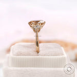 Oval champagne moissanite three stone ring displayed on box