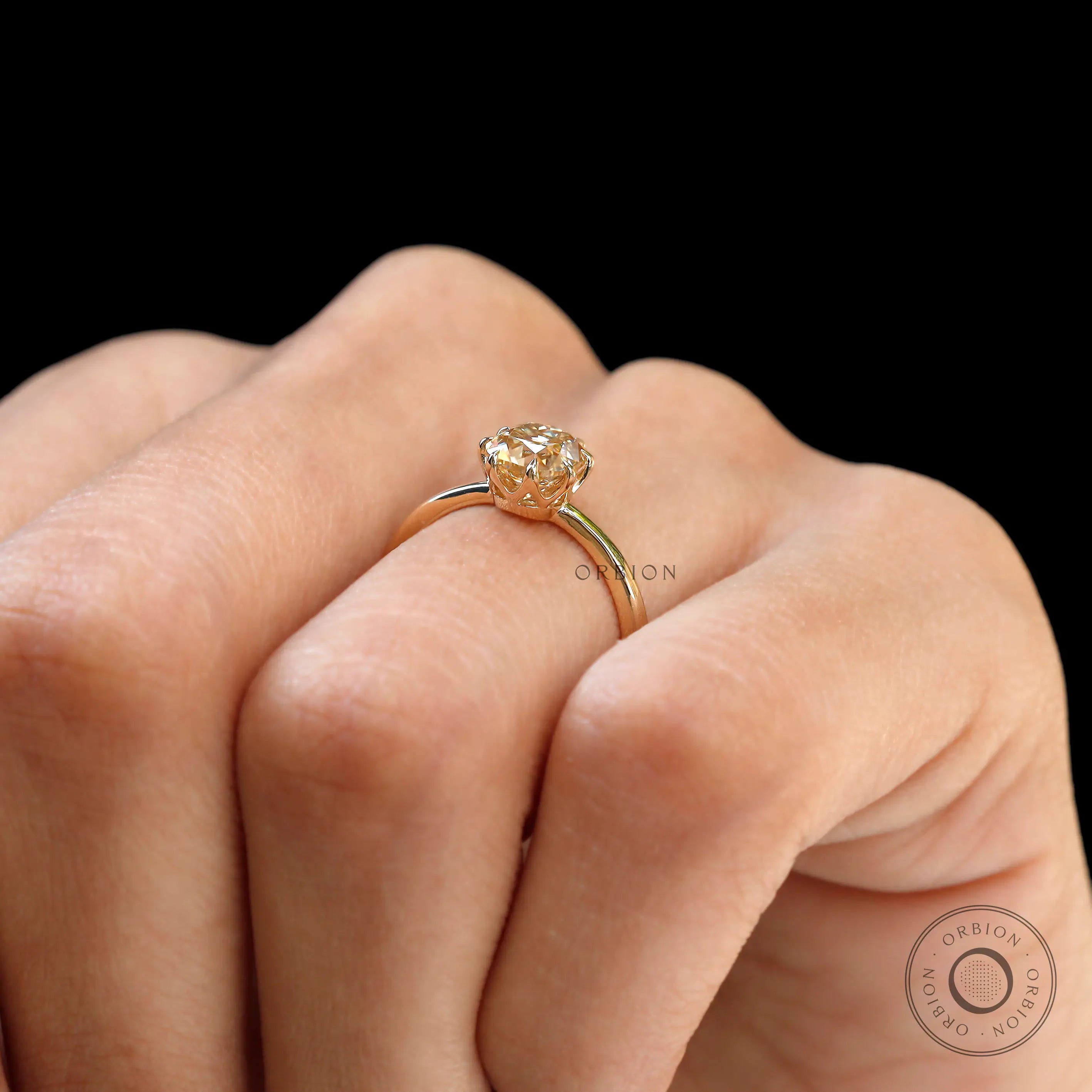 Hand wearing Champagne Moissanite solitaire engagement ring with neutral