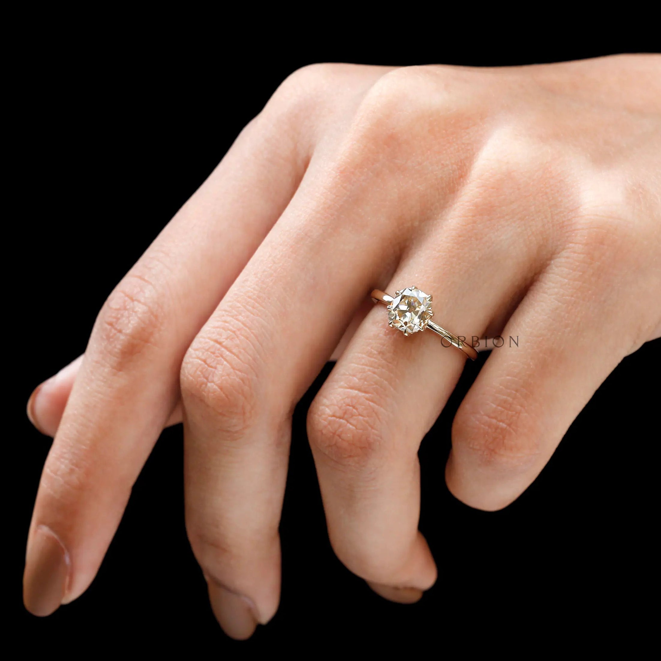 Side rare view of solitaire engagement ring worn on hand