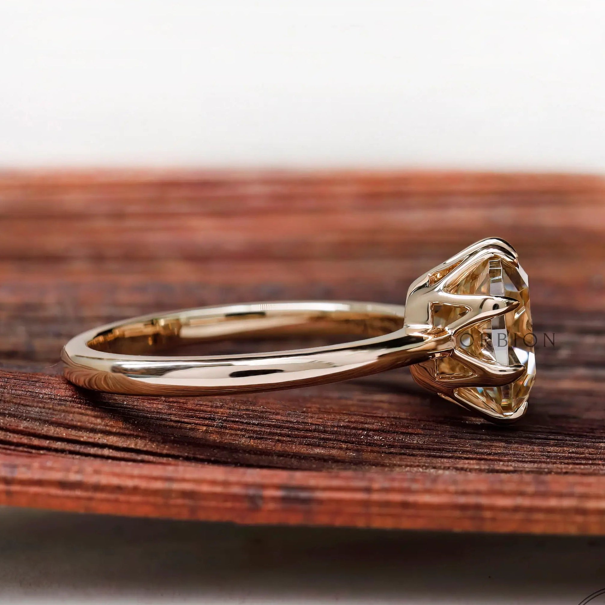 Side profile of cushion Old Mine Cut moissanite solitaire ring in 10K yellow gold