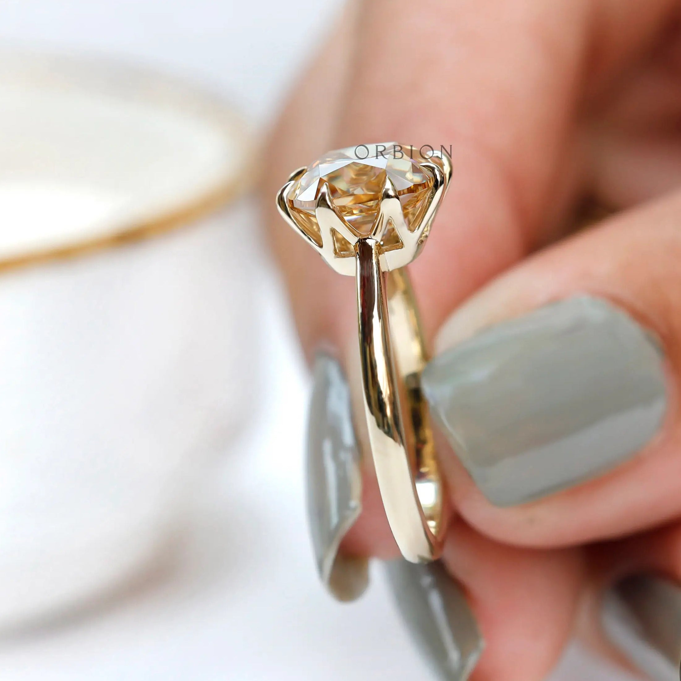 Angled view highlighting prong setting and crown of moissanite solitaire ring