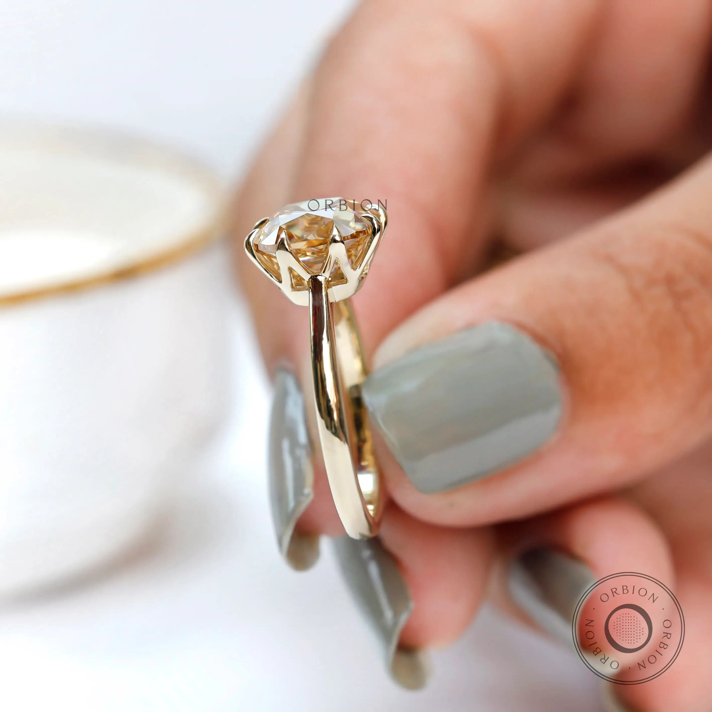 Angled view highlighting prong setting and crown of moissanite solitaire ring