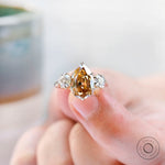 Yellow gold pear champagne moissanite  trilogy wedding ring close up