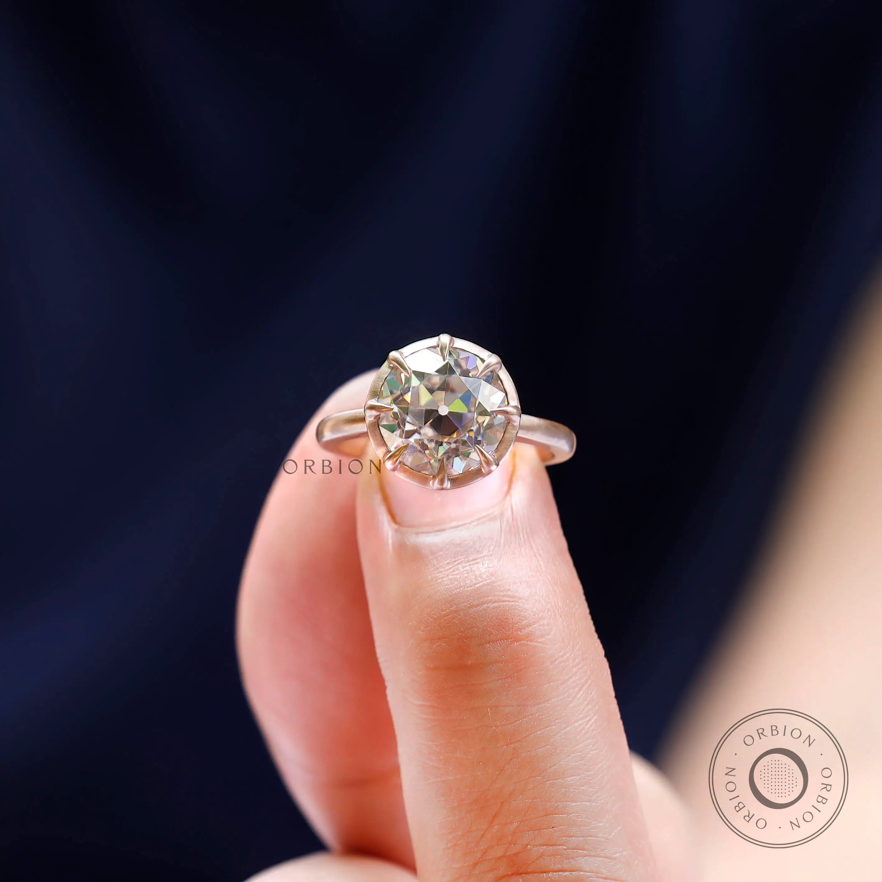 Finger close-up of round moissanite engagement ring