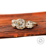 Angled view of three stone cushion moissanite ring in yellow gold