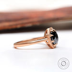 Side profile of black moissanite halo ring in 10K rose gold