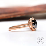 Side profile of black moissanite halo ring in 10K rose gold
