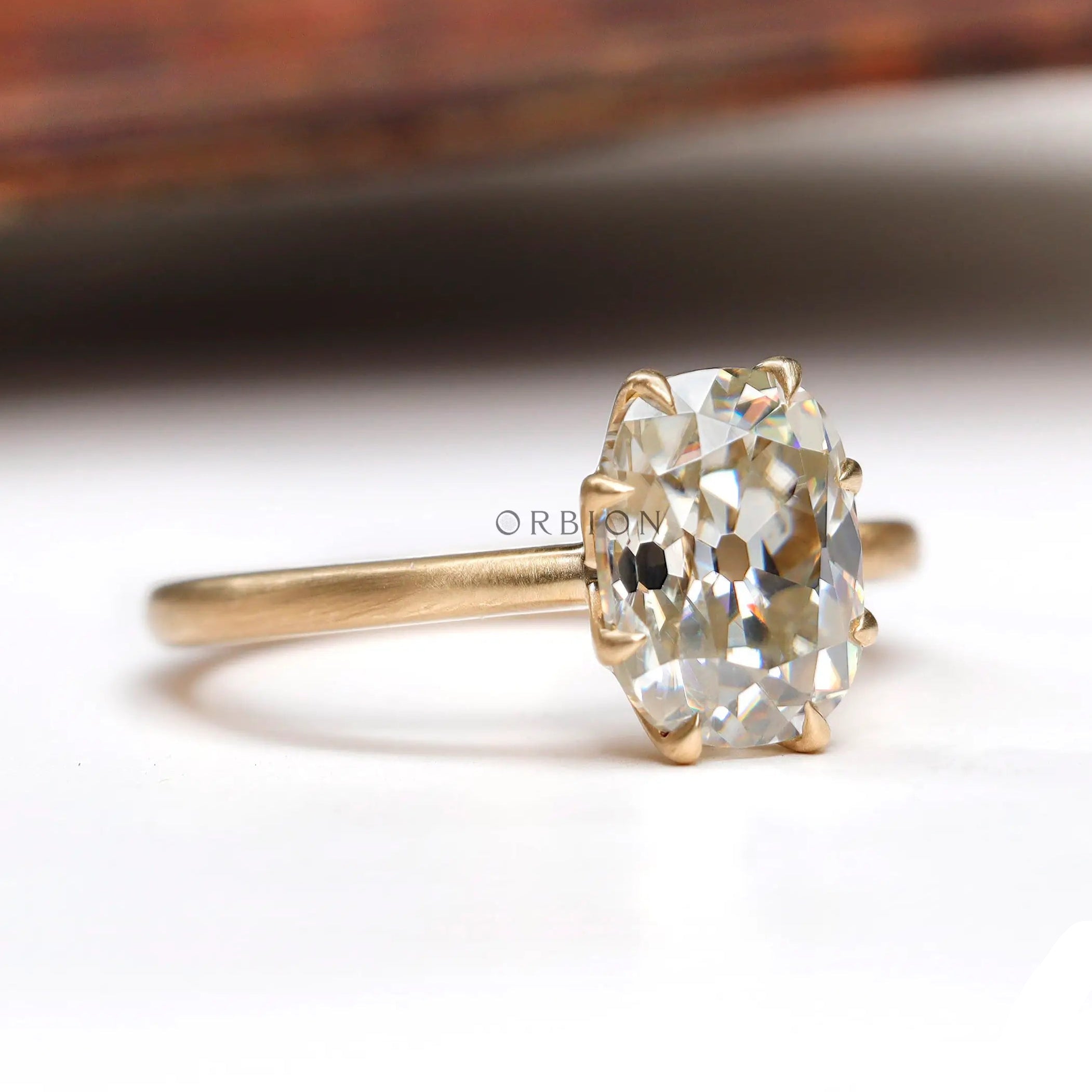 Rear view of elongated cushion moissanite ring with polished yellow gold band