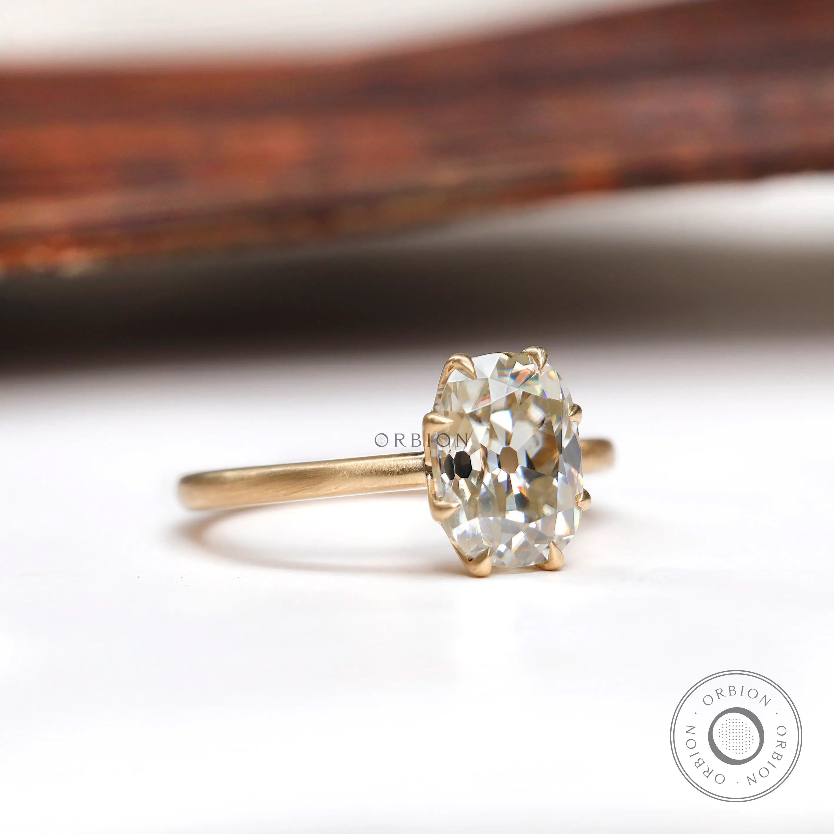 Rear view of elongated cushion moissanite ring with polished yellow gold band