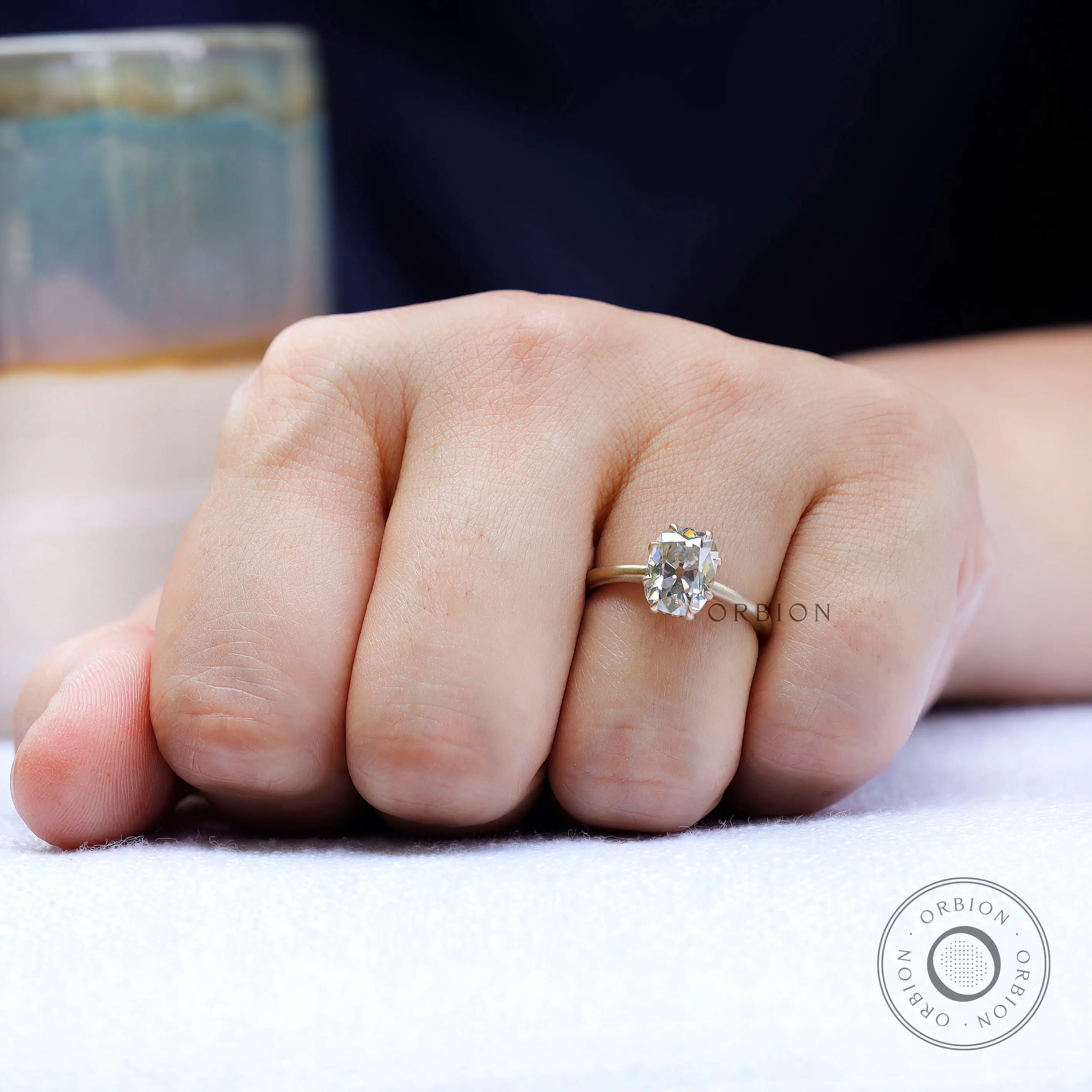 Lifestyle hand shot of yellow gold moissanite solitaire ring