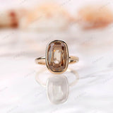 Front view of elongated cushion champagne moissanite bezel ring in yellow gold.
