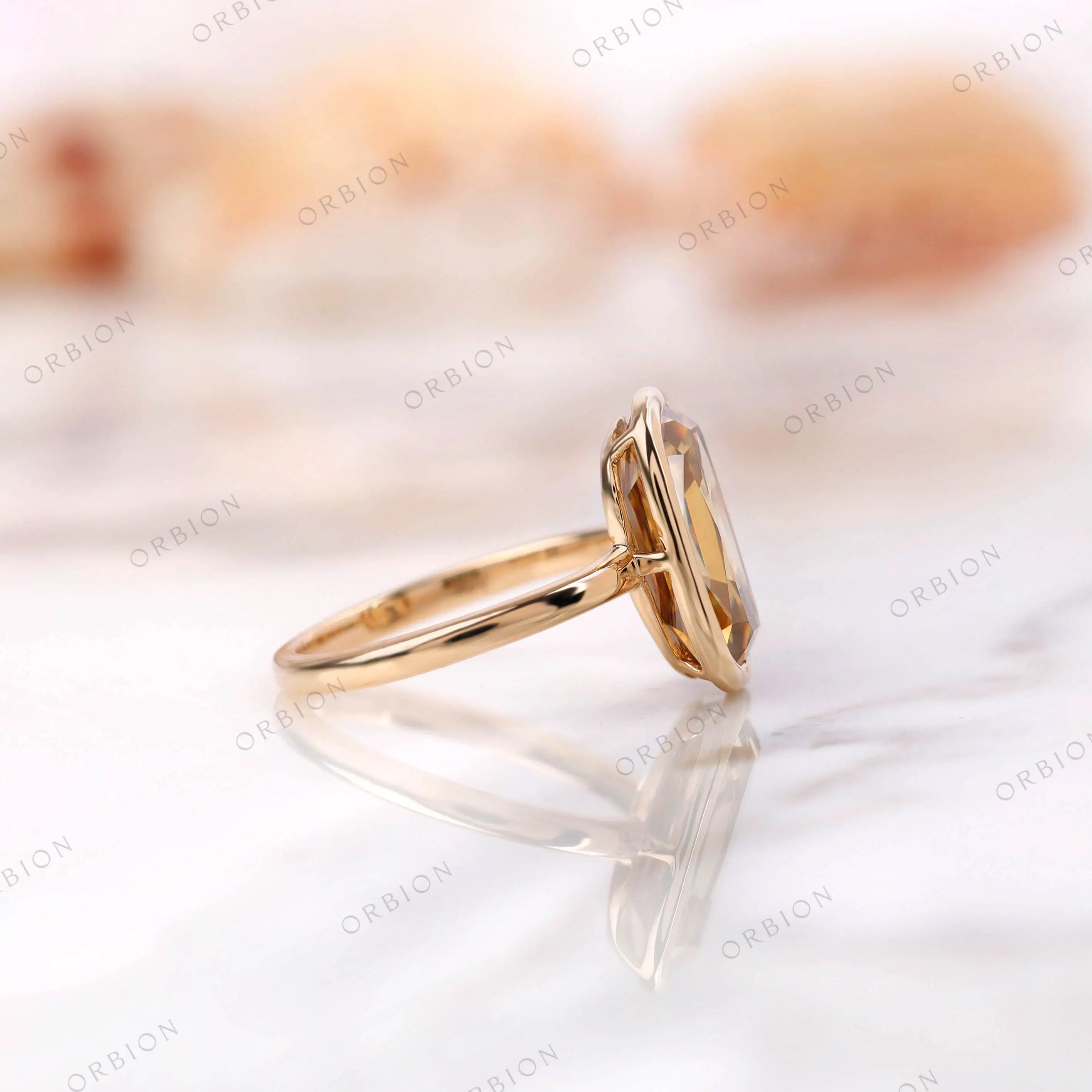 Side view of of champagne moissanite bezel ring with elongated cushion stone.