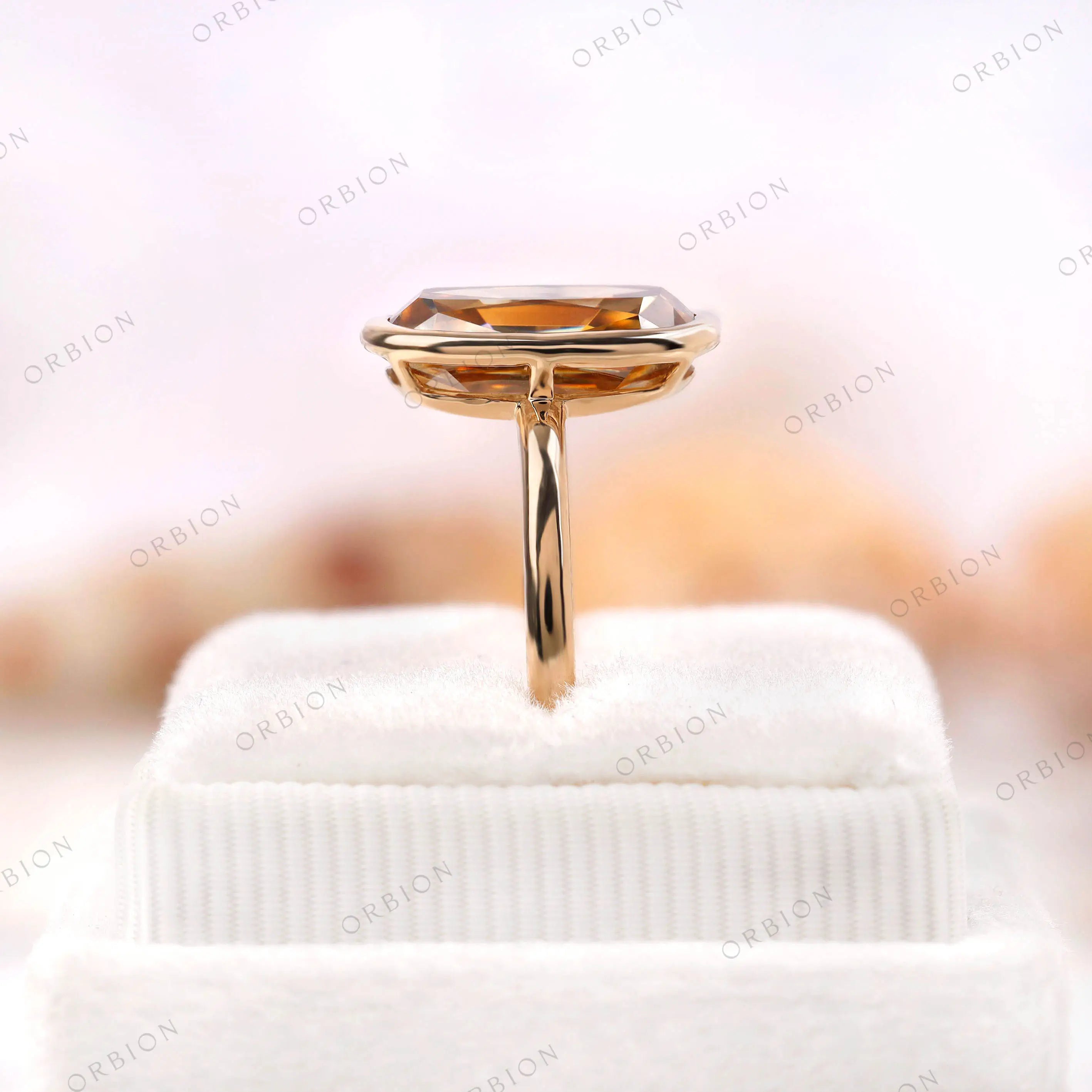 Detailed rear side view of champagne moissanite bezel ring on box