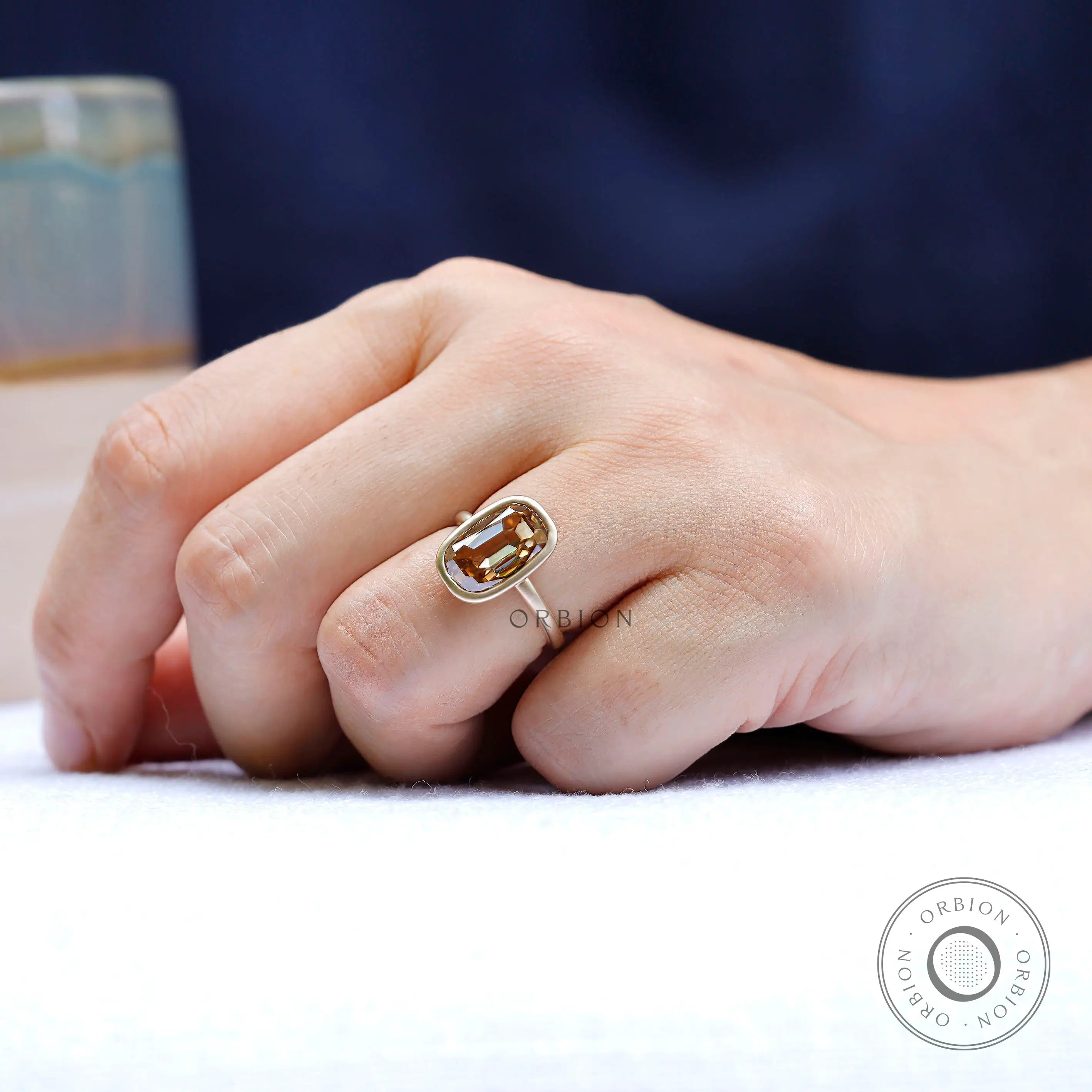 Champagne moissanite bezel ring worn on hand