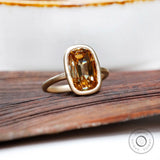 Matt finish yellow gold bezel moissanite ring side view