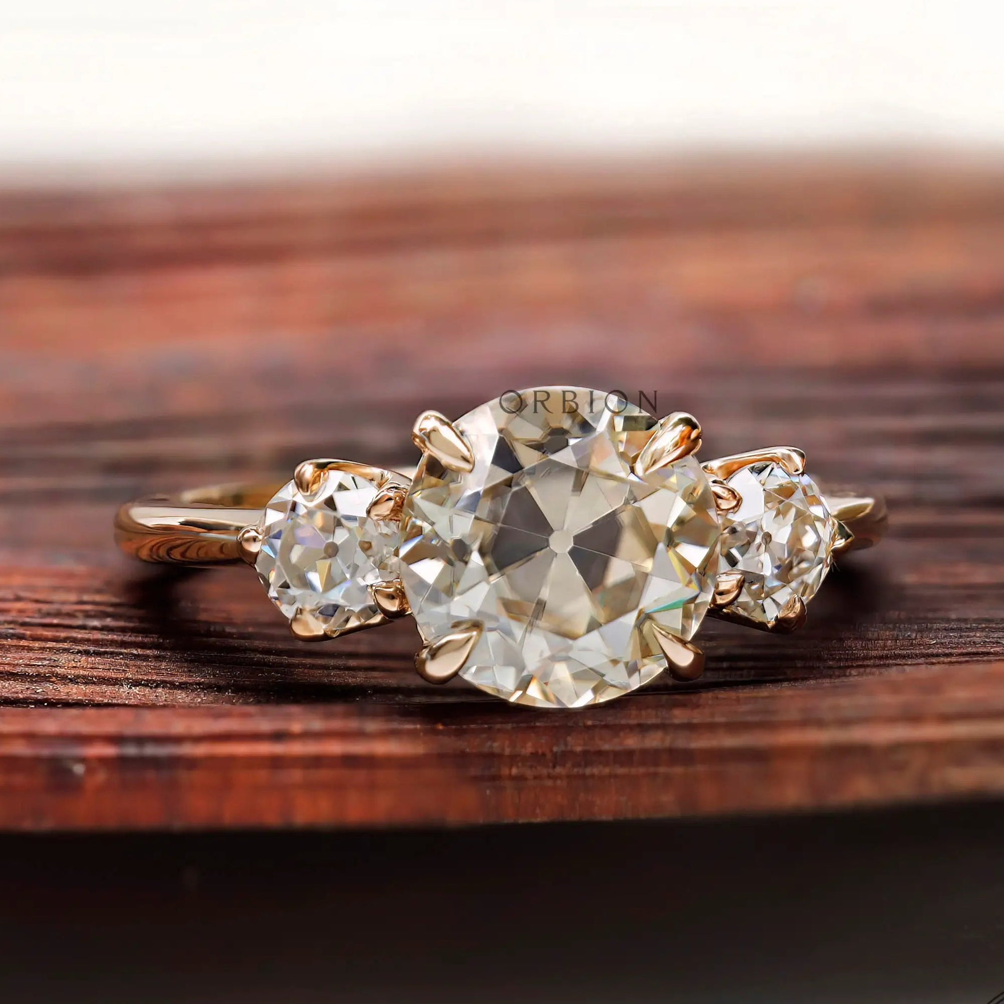 Three stone Old European cut moissanite ring top view in yellow gold