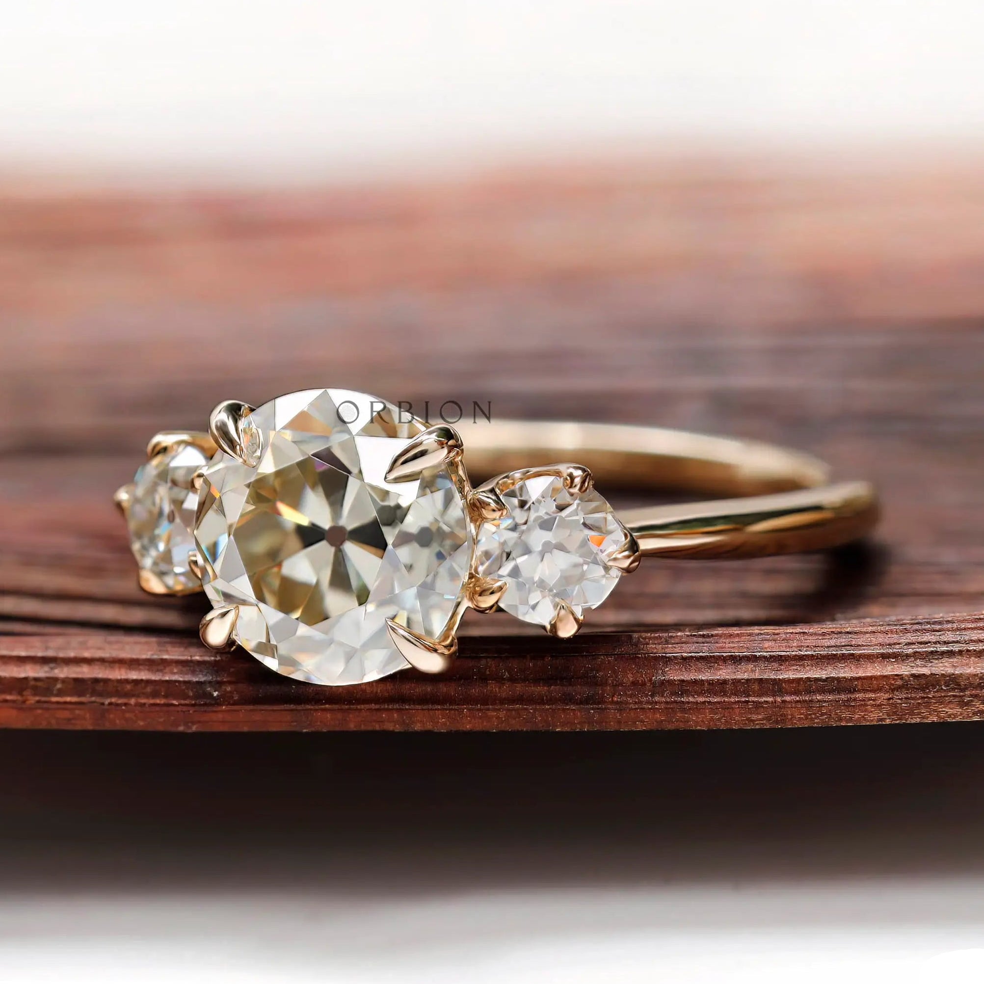 Profile view of three stone moissanite ring showing prong setting