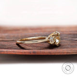 Side angle view of three stone moissanite ring with round stones