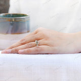 Hand worn three stone moissanite ring side perspective