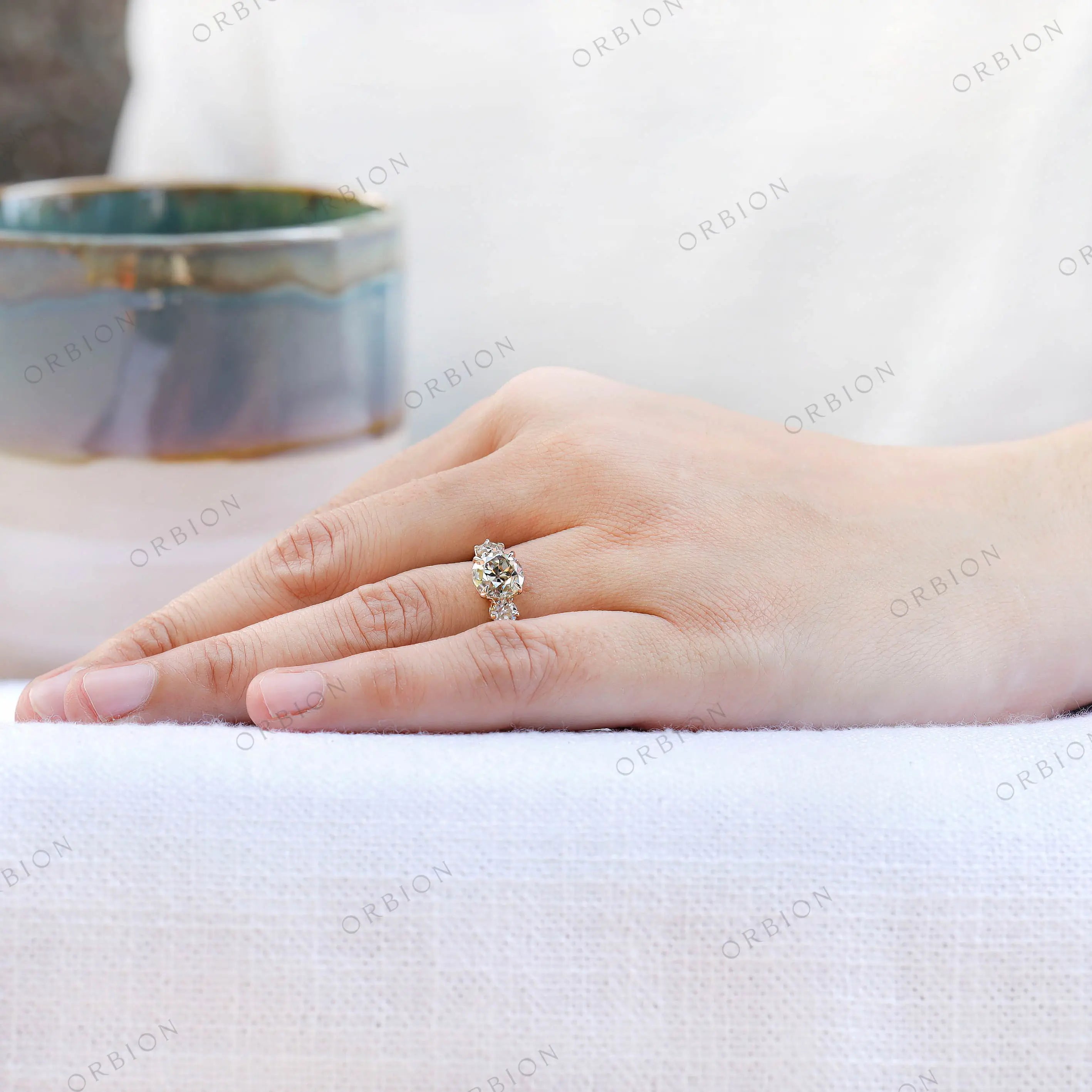 Hand worn three stone moissanite ring side perspective