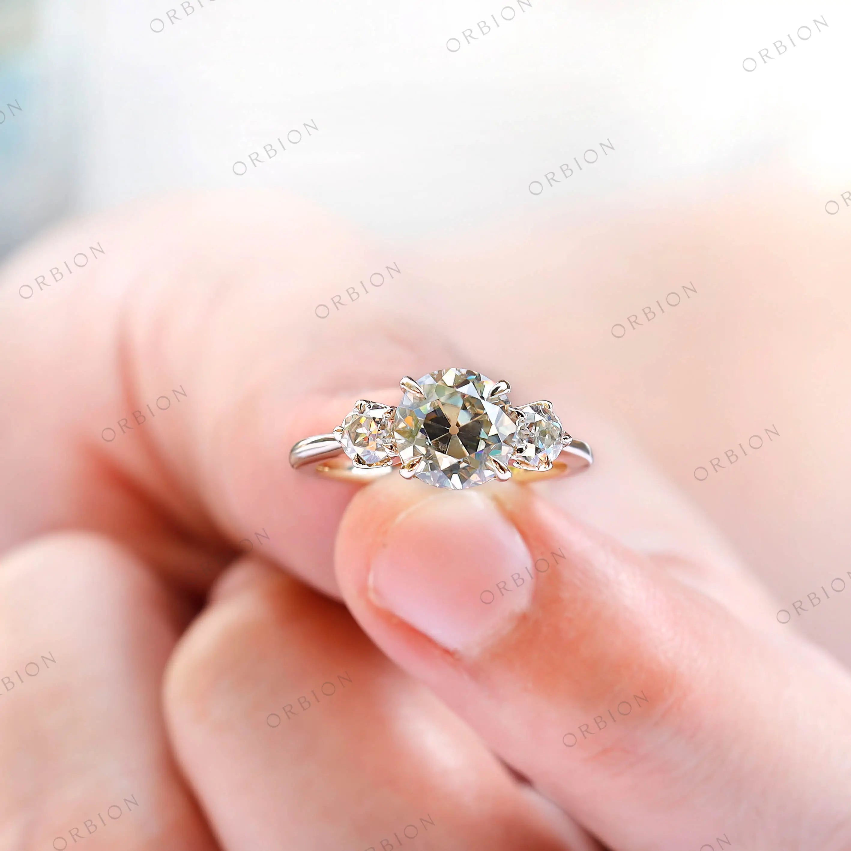 Close detail of round moissanite side stones in prong setting