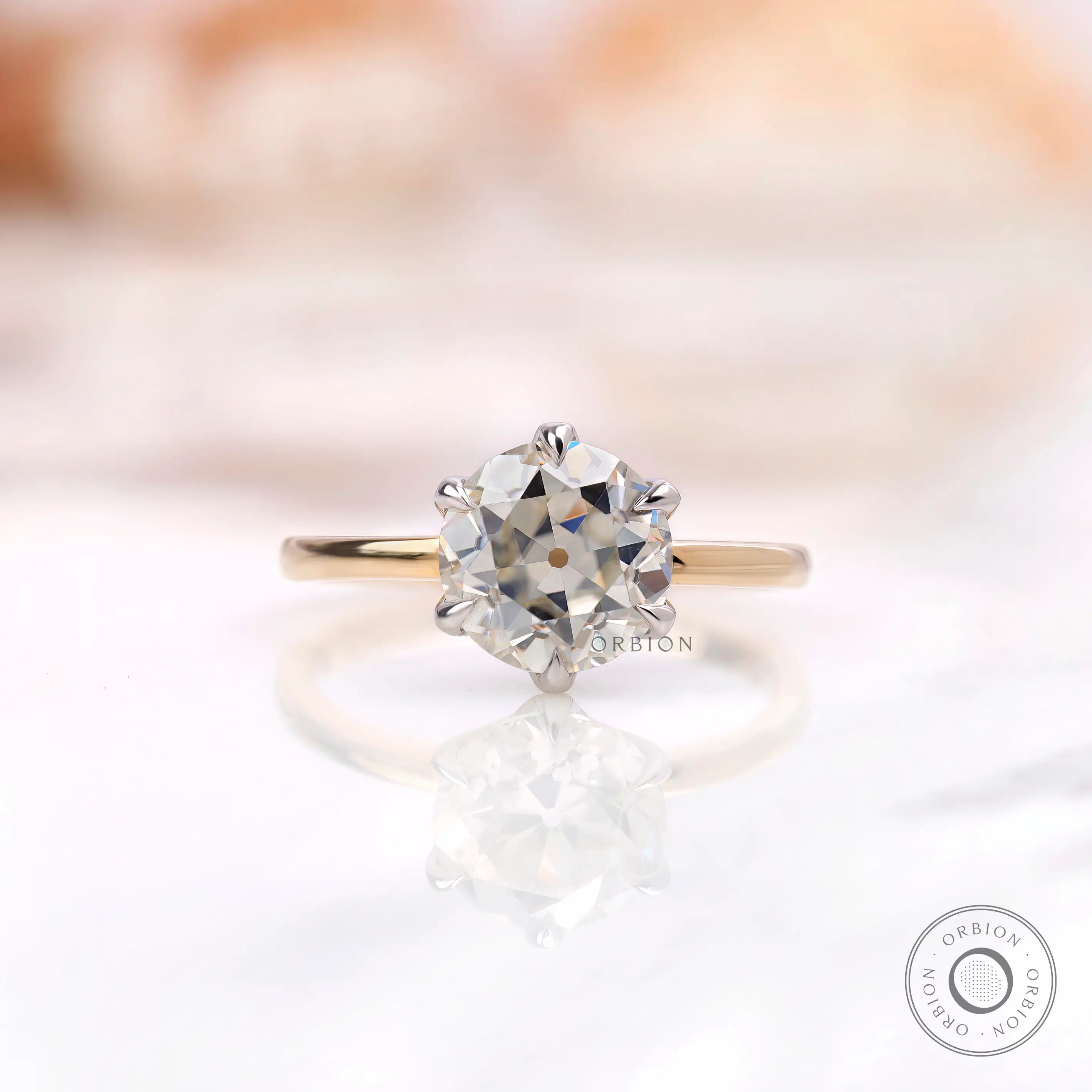 Front view of six prong solitaire OEC Moissanite ring in dual-tone gold.