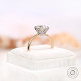 Angled view of OEC Moissanite set in six-prong setting on box.